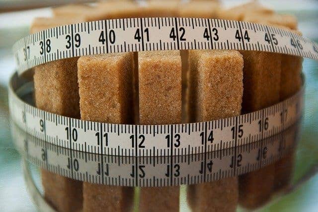 cubos de açúcar amarrados com uma fita métrica