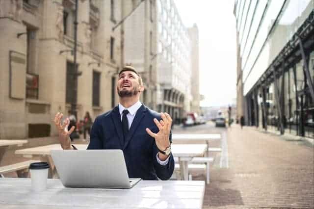  Um homem nervoso a trabalhar no seu portátil