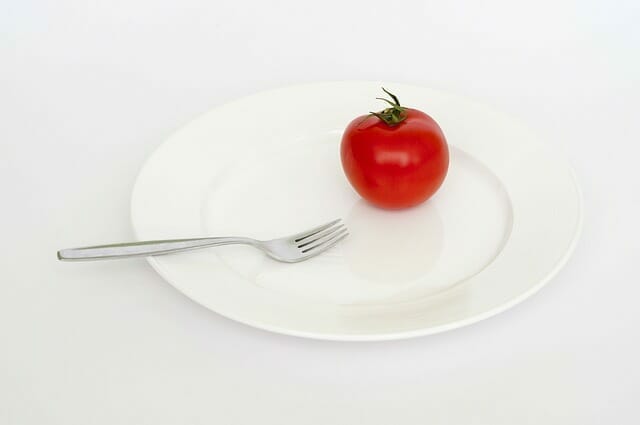  Um tomate e um garfo no seu prato
