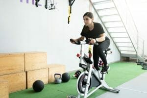  mulher treina em bicicleta estacionária