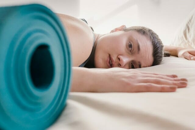  mulher exausta da formação, junto ao tapete de exercício
