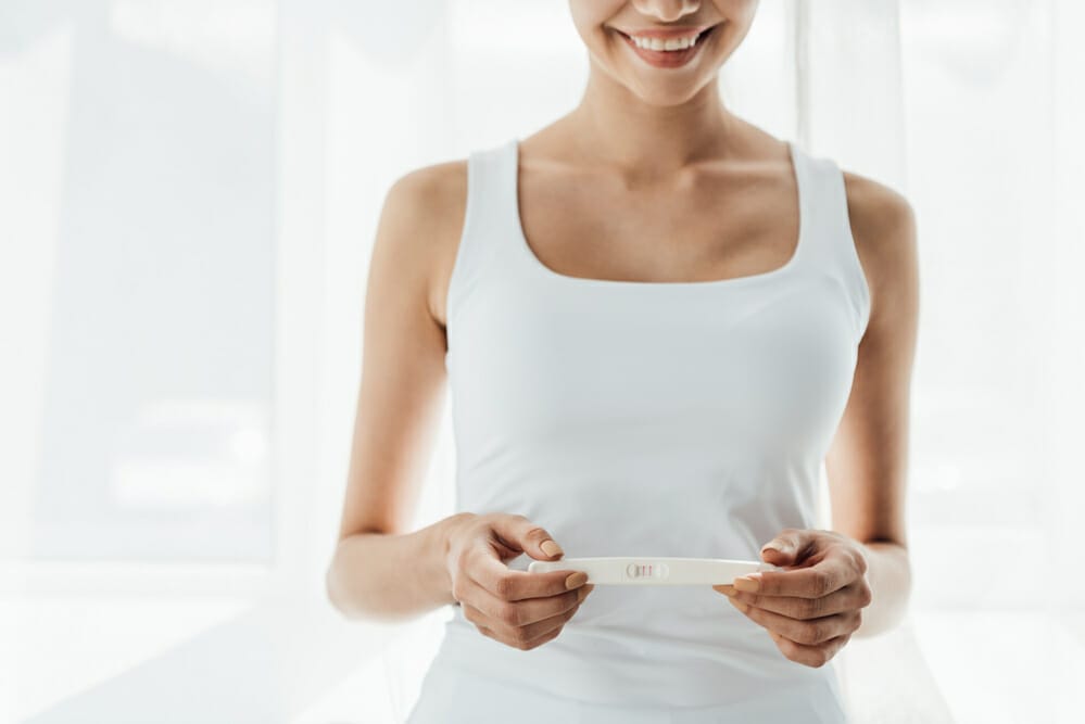  uma mulher satisfeita realiza um teste de gravidez positivo