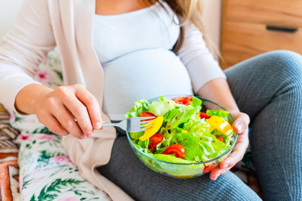  mulher grávida come salada